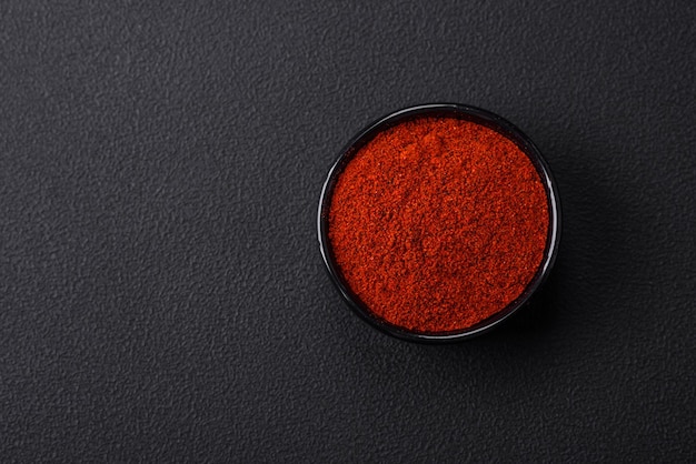 Photo paprika fumé aux épices sous forme de poudre dans des bols et des cuillères