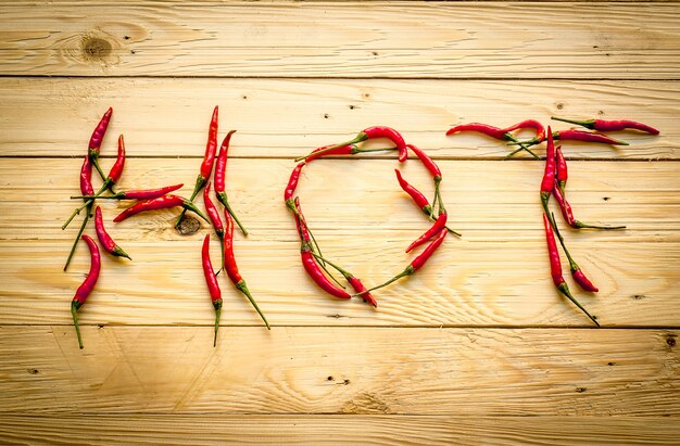 Paprika sur le plancher en bois Écrivez le mot chaud