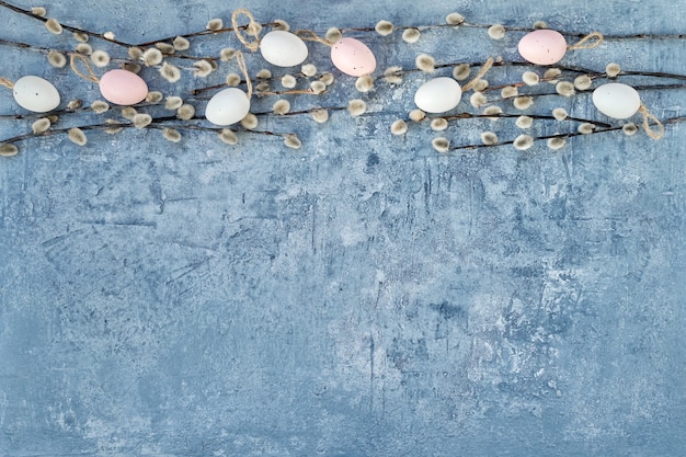 Pâques. Branche de saule, oeufs de Pâques roses et blancs sur bleu. Vue de dessus, copie