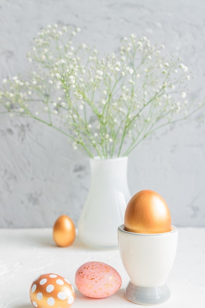 Pâques nature morte aux oeufs et fleurs de gypsophile en fleurs sur fond gris