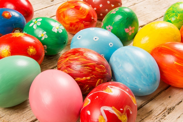 Pâques avec des oeufs colorés à la main sur une table en bois.