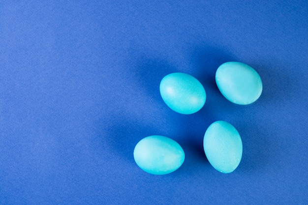 Pâques peint des oeufs bleus sur un fond bleu tendance.