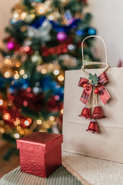 Paquet d'artisanat avec un cadeau sur le fond d'un arbre de Noël