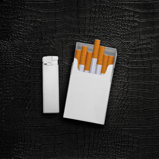 Paquet de cigarettes et briquets sur fond de cuir noir