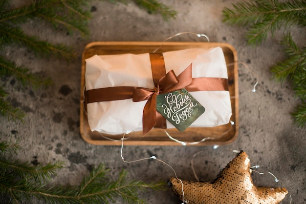 Un paquet de Noël décoré d'un ruban se trouve avec l'étiquette Happy New Year