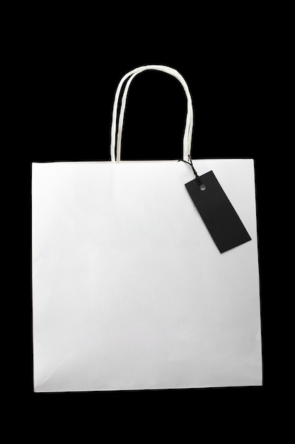 Un paquet de papier blanc vide avec étiquette vierge sur fond noir Espace de copie