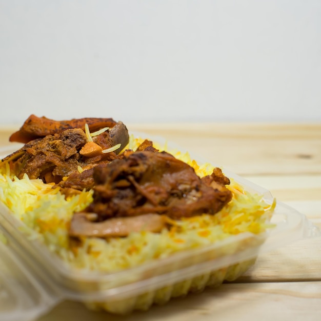 Un paquet en plastique de riz mandy d'agneau sur fond de bois La meilleure nourriture arabe Mise au point sélective