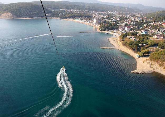 Le parachute ascensionnel au-dessus de l'eau près de la côte de la ville de Dzhubga