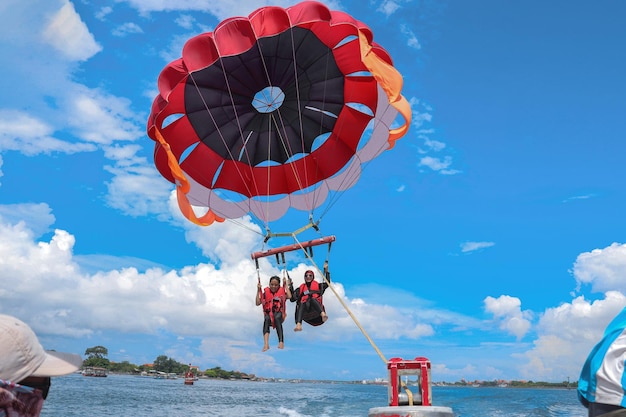 Parachute ascensionnel au-dessus de l'océan sur une île tropicale vacances en famille couple lune de miel
