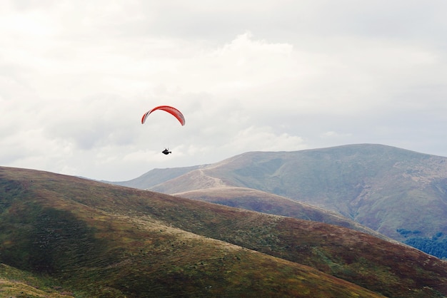 Parachutisme parachutiste volant dans les nuages à l'espace de concept d'aventure de voyage en montagne pour le texte