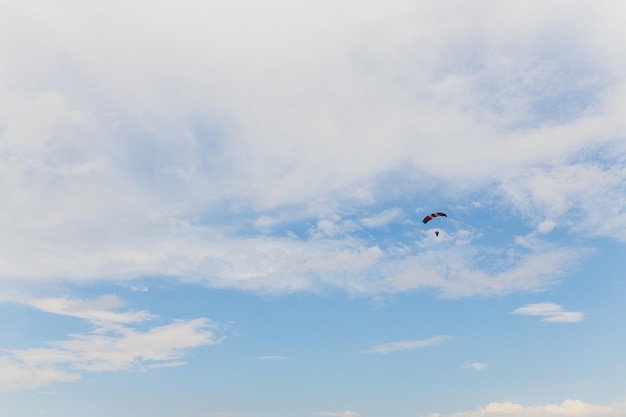 Un parachutiste glissant avec un parachute de couleur drapeau russe contre le ciel bleu.