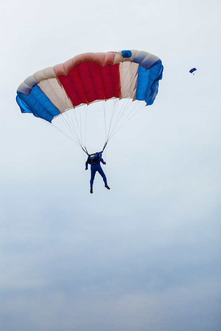 Photo parachutiste masculin sous un parachute multicolore