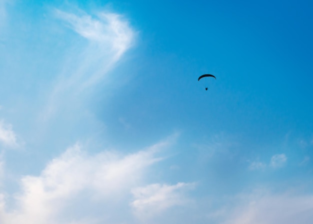 Parachutiste planant dans un beau ciel bleu avec des nuages légers Parapente Se sentir libre dans le ciel