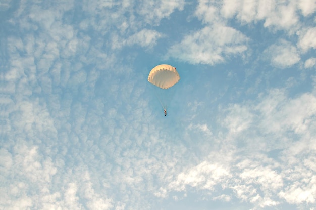 Un parachutiste vole dans le contexte d'un ciel nuageux