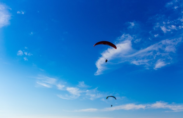 Parapente dans le ciel bleu. Parachute avec parapente vole. Sports extrêmes, concept de liberté