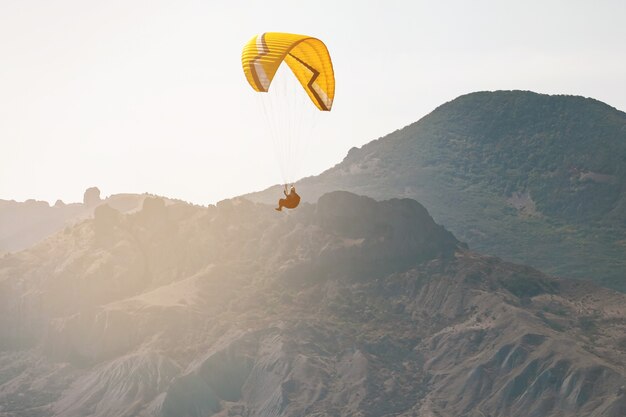 Parapente dans le ciel sur la mer et les montagnes