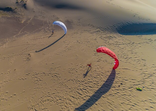 Parapente sur le fond de la vue de dessus des dunes de sable