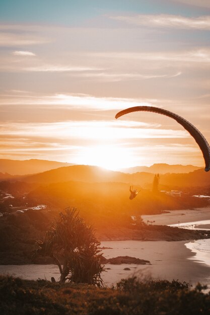 Photo parapente sur la plage avec coucher de soleil