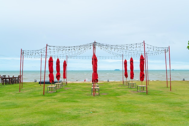 Parapluie avec ampoule d'éclairage sur cour avec fond de plage de mer