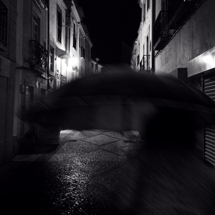 Photo parapluie au milieu des bâtiments contre la nuit