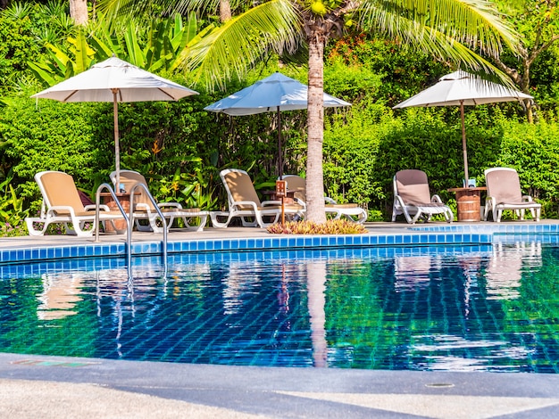 Parapluie et chaise autour de la piscine extérieure de luxe