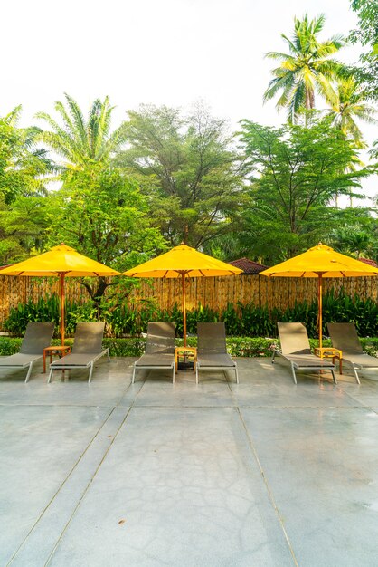 Parapluie et décoration de lit de piscine autour de la piscine de l'hôtel