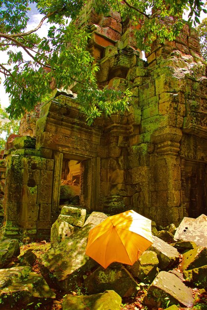 Photo parapluie jaune à l'ancienne ruine du temple d'angkor wat