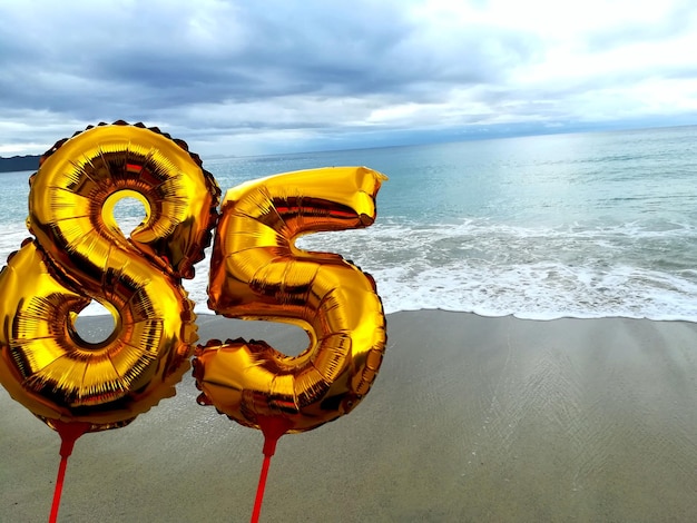 Photo parapluie jaune sur la plage contre le ciel