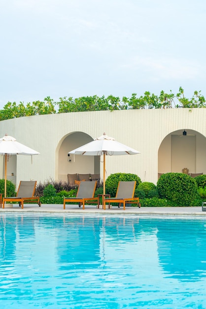 parapluie avec lit piscine autour de la piscine avec fond de mer océanique - concept de vacances et de vacances