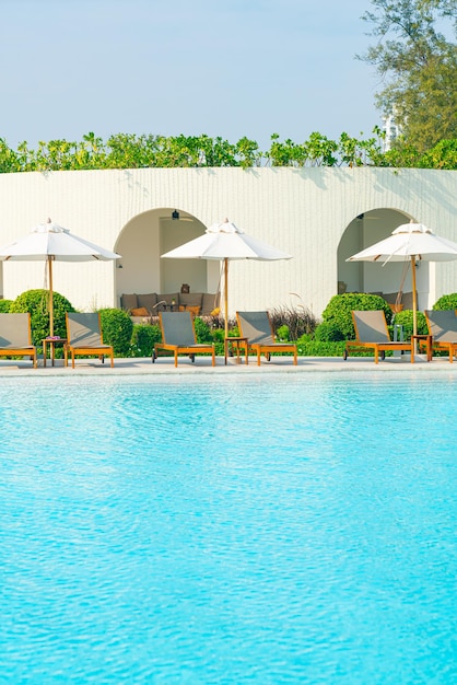 parapluie avec lit piscine autour de la piscine avec fond de mer océanique - concept de vacances et de vacances