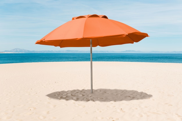 Photo parapluie orange sur le collage de plage