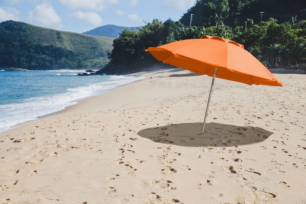 Parapluie orange sur le collage de plage