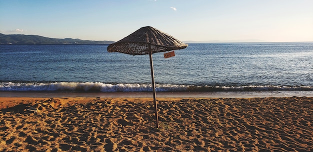 Photo parapluie sur la plage et le ciel bleu