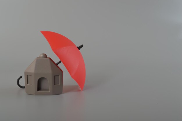 Photo parapluie rouge et modèle de maison jouet protection de l'assurance logement et de la sécurité et de la sûreté