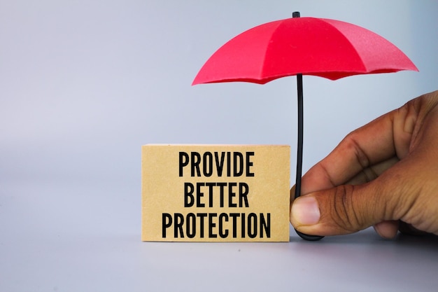 Photo parapluie rouge et papier avec les mots offrent une meilleure protection concept de couverture d'assurance