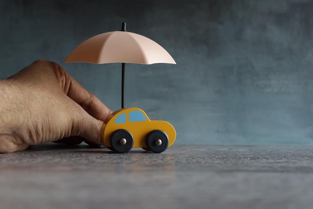 Parapluie et voiture jouet avec espace de copie Concept de protection et d'assurance automobile