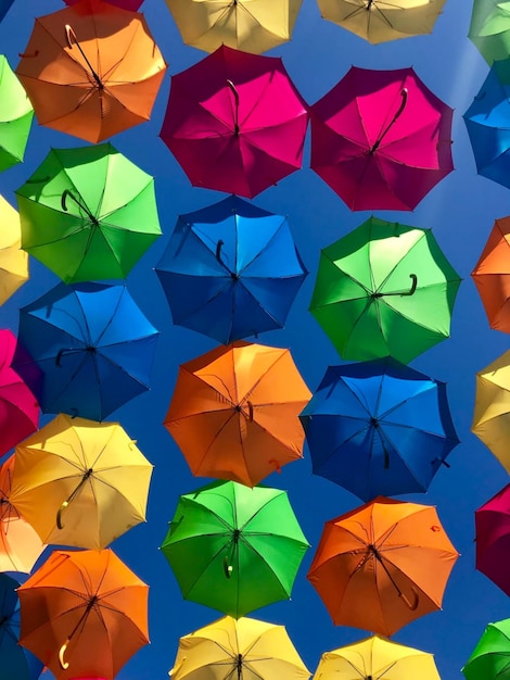 Photo des parapluies colorés en arrière-plan des paraplus colorés dans le ciel bleu