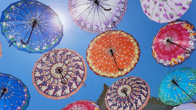 Parapluies colorés flottant au-dessus de la rue.