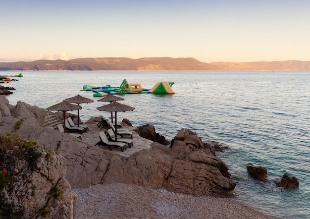 Parapluies de paille sur la plage de Rabac en Croatie