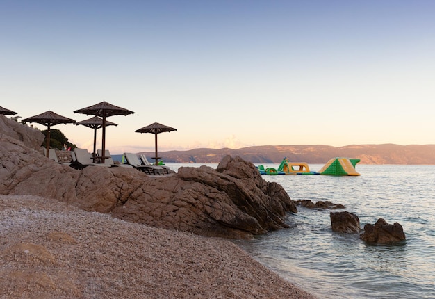 Photo parapluies de paille sur la plage de rabac en croatie