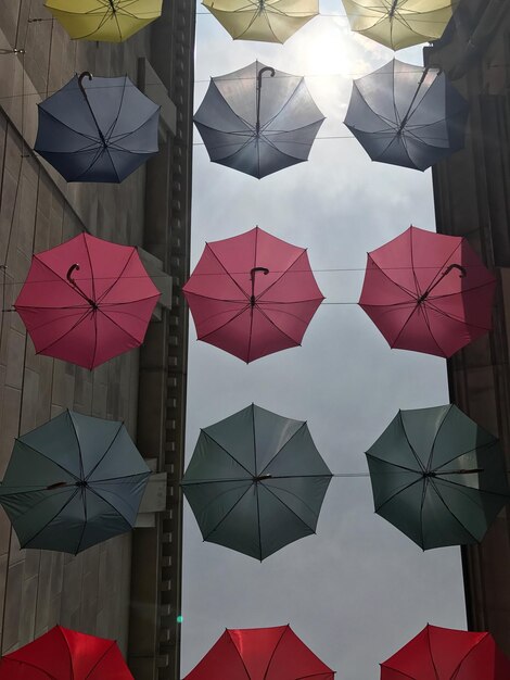 Photo des parapluies suspendus contre une structure construite