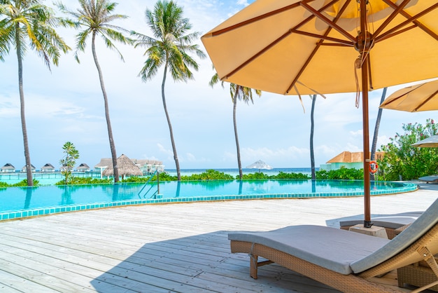 Parasol et chaise autour de la piscine dans un hôtel de villégiature