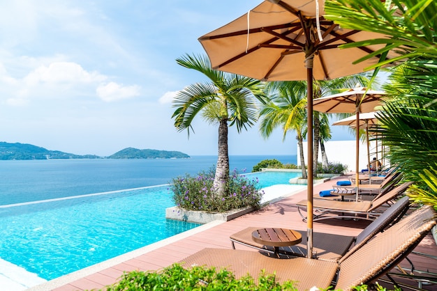 Parasol et chaise autour de la piscine de l&#39;hôtel et du complexe