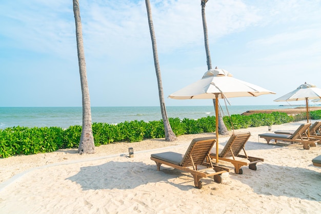 Parasol avec chaise de plage et fond de mer océan - concept de vacances et de vacances