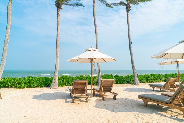 Parasol avec chaise de plage et fond de mer océan - concept de vacances et de vacances