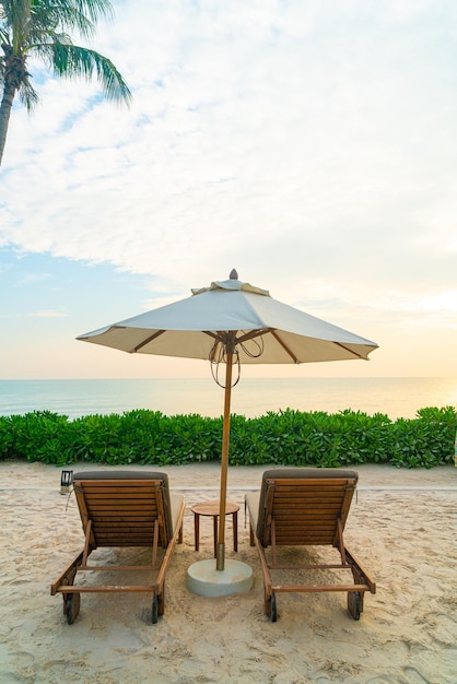 Parasol avec chaise de plage et fond de mer océan - concept de vacances et de vacances