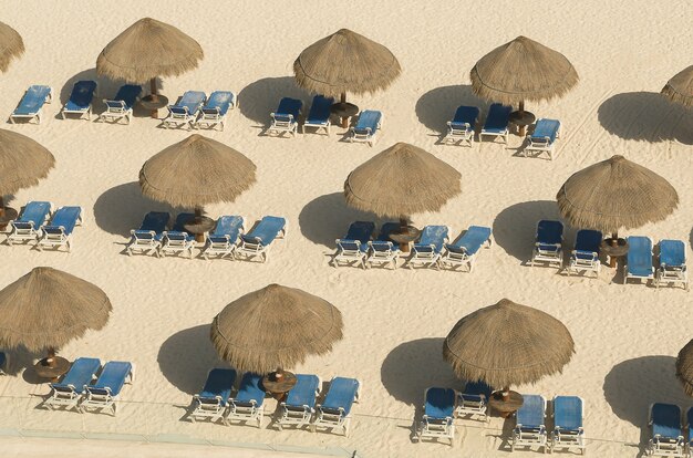 Parasol de fauteuils dans le sable de Cancun