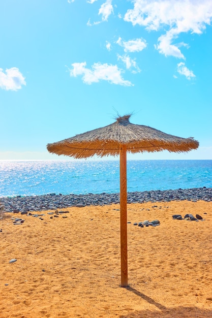 Parasol sur la plage de sable au bord de la mer