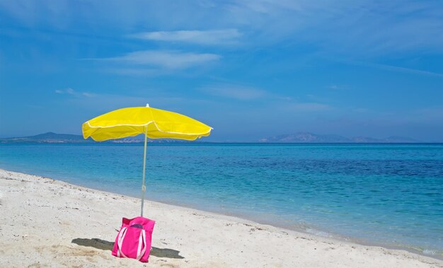 Parasol et sac sur une plage déserte