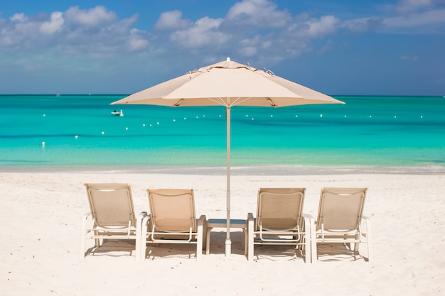 Parasols blancs et chaises longues sur une plage tropicale